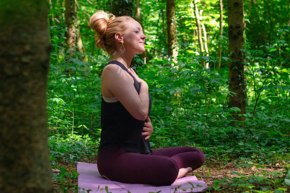 Mirka meditiert im Wald.